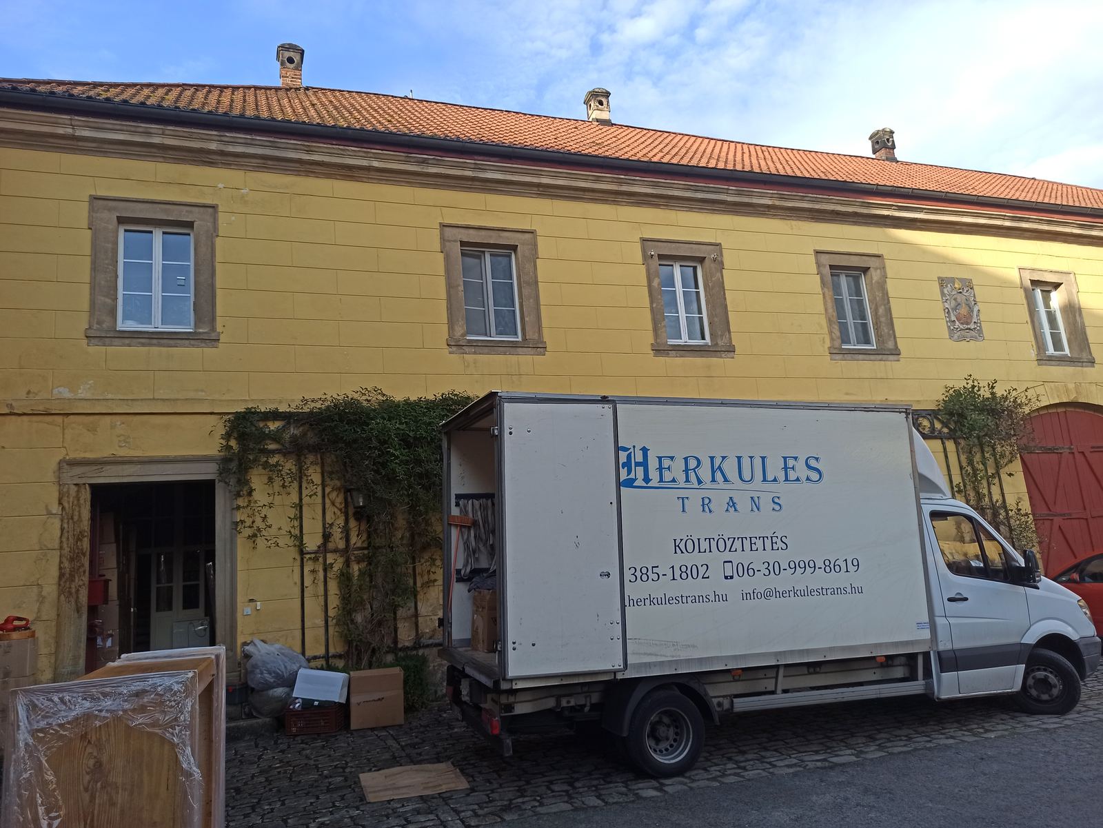 Herkules-Trans teherautó műemlék épület udvarán, bútorszállítás Herkules-Trans teherautó egy műemlék épület udvarán, fóliázott bútorokkal és dobozokkal a berakodásnál