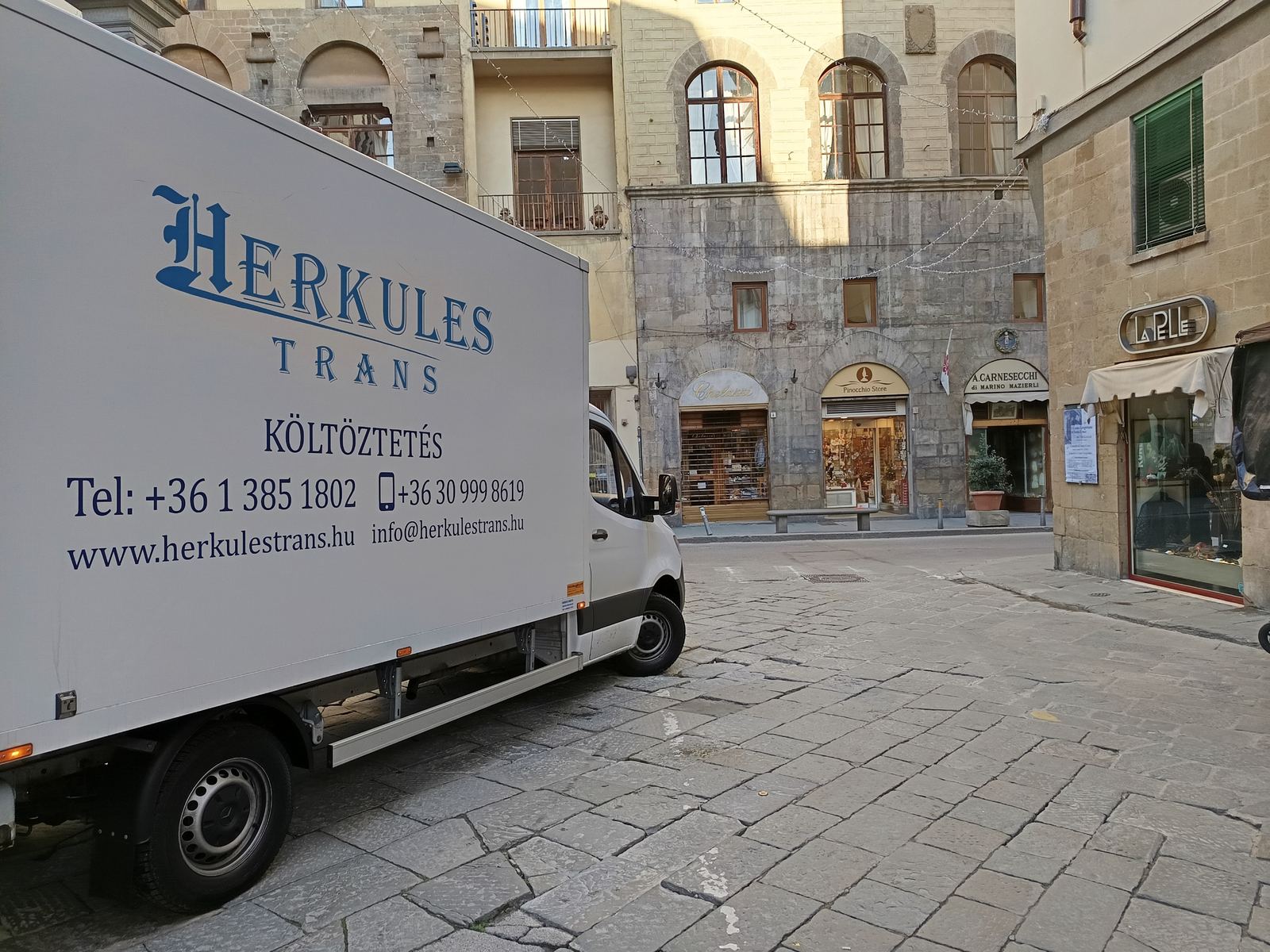 Herkules-Trans teherautó olasz óvárosban, nemzetközi költöztetés Herkules-Trans költöztető teherautó egy olasz óváros macskaköves utcáján nemzetközi költöztetés közben
